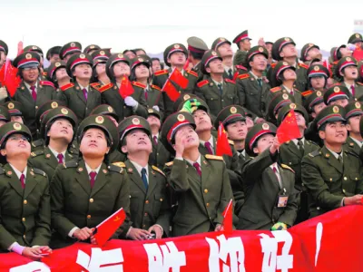 Soldiers watch the Long March CZ-2F rocket carrying the Shenzhou VI blast off at the Jiuquan Satellite Launch Center, October 12, 2005. China's second manned spacecraft blasted off from a remote northwestern launch site on Wednesday, two years after the country joined an elite club of space powers. CHINA OUT REUTERS/China Newsphoto------2k