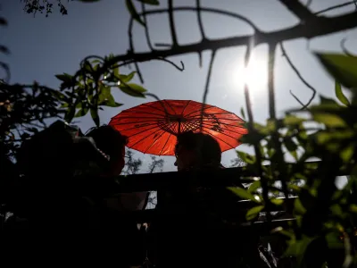 A woman uses an umbrella during an unusual winter period heatwave in Santiago, Chile, August 3, 2023. REUTERS/Ivan Alvarado