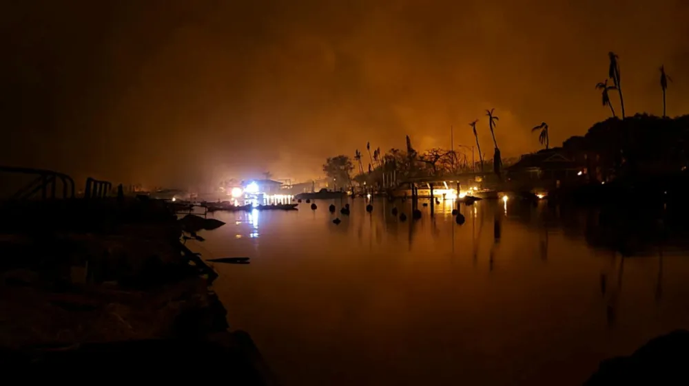 Flames are seen near Lahaina as wildfires driven by high winds destroy a large part of the historic town of Lahaina, in Kahului, Hawaii, U.S. August 9, 2023. Dustin Johnson/Handout via REUTERS THIS IMAGE HAS BEEN SUPPLIED BY A THIRD PARTY.