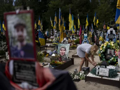 Natalie Zaichenko, 60, tends to the grave of her son, a Ukrainian soldier who was killed in the war against Russia, in Kyiv, Ukraine, Thursday, Aug. 3, 2023. (AP Photo/Jae C. Hong)