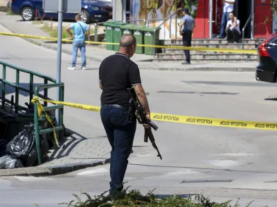 A plain-clothes police officer holds a rifle as they launch a major chase for a man who claimed to have shot and killed his wife while broadcasting it live on Instagram, in the small town of Gradacac, Bosnia, Friday, Aug. 11, 2023. (AP Photo)