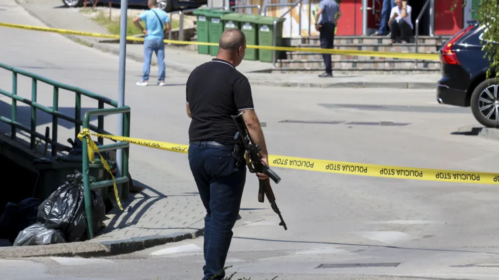 A plain-clothes police officer holds a rifle as they launch a major chase for a man who claimed to have shot and killed his wife while broadcasting it live on Instagram, in the small town of Gradacac, Bosnia, Friday, Aug. 11, 2023. (AP Photo)