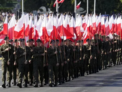 Members of the new voluntary Territorial Defense Troops march with Poland's national flags in a massive military parade to celebrate the Polish Army Day, commemorating the 1920 battle in which Polish troops defeated advancing Bolshevik forces, in Warsaw, Poland, Tuesday, Aug. 15, 2023. Poland is holding a military parade to showcase its state-of-the-art weapons and defense systems, as war rages across its southeastern border in neighboring Ukraine and ahead of parliamentary elections scheduled for Oct. 15. (AP Photo/Czarek Sokolowski)