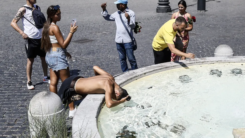 Tourists cool off at a fountain in Rome's Piazza del Popolo, as the African anticyclone is rising temperatures again all over Italy, starting a new heat wave. (Cecilia Fabiano/LaPresse via AP)