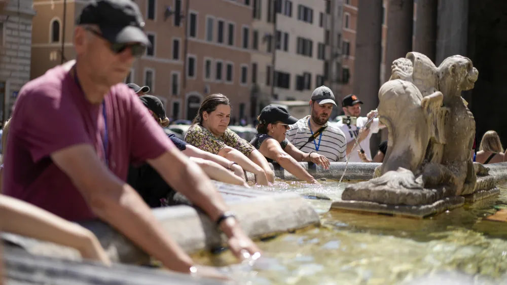 People cool off at a fountain in front of the Pantheon, in Rome, Saturday, Aug. 19, 2023. Italy is facing a heat wave with temperatures in the capital as high as 37 Celsius (98 Farenheit). (AP Photo/Andrew Medichini)