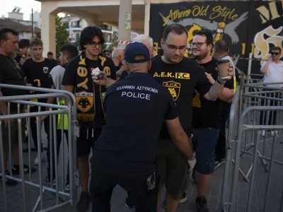 A police officer checks a soccer fan prior to the Champions League third qualifying round match between AEK Athens and Dinamo Zagreb, in Nea Philadelphia suburb, Athens, Greece, Saturday, Aug. 19, 2023. UEFA president Aleksander Ceferin met with Greece's prime minister Kyriakos Mitsotakis on Wednesday and promised to do more to deal with organized violence in soccer in the wake of a deadly attack led by Croatian fans in Athens. (AP Photo/Michael Varaklas)