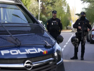 Police officers stand guard as they cordon off the area next to the Ukrainian embassy in Madrid, Spain, Wednesday, Nov. 30, 2022. Spain's Interior Ministry says police are investigating reports of a blast at the Ukrainian embassy in Madrid. The ministry says police were told an employee at the embassy was slightly injured handling a letter in what it described as "a deflagration." (AP Photo/Paul White)