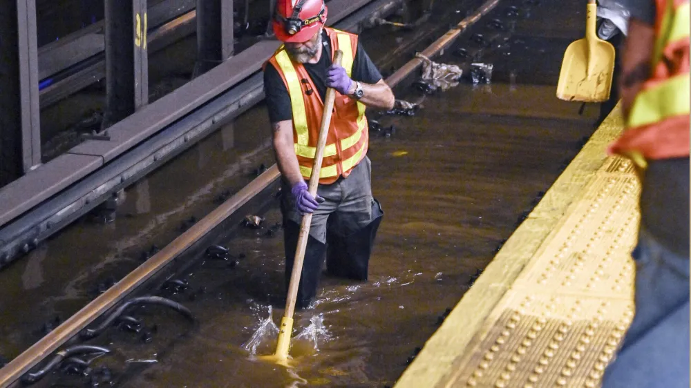 This photo, provided by MTA New York City Transit, shows an MTA worker knee-deep in water on subway tracks from a water main break in New York's Times Square, Tuesday, Aug. 29, 2023. A 127-year-old, 20-inch water main under New York's Times Square gave way early Tuesday, flooding midtown streets and the city's busiest subway station. (Marc A. Hermann / MTA, via AP)