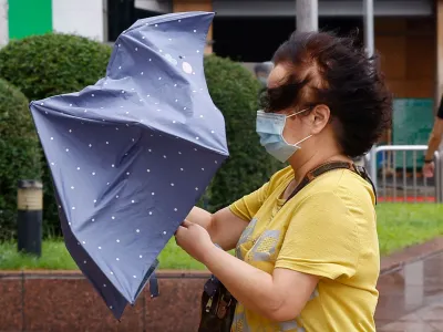 A woman holds an umbrella while walking on the streets in Taipei after the Haikui Typhoon hit Taiwan, in Taipei, Taiwan September 4, 2023. REUTERS/Ann Wang