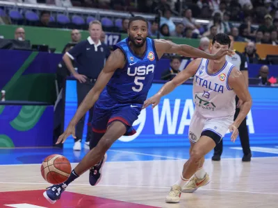 U.S. forward Mikal Bridges (5) drives past Italy forward Simone Fontecchio (13) during the Basketball World Cup quarterfinal game between Italy and U.S. at the Mall of Asia Arena in Manila, Philippines, Tuesday Sept. 5, 2023. (AP Photo/Michael Conroy)