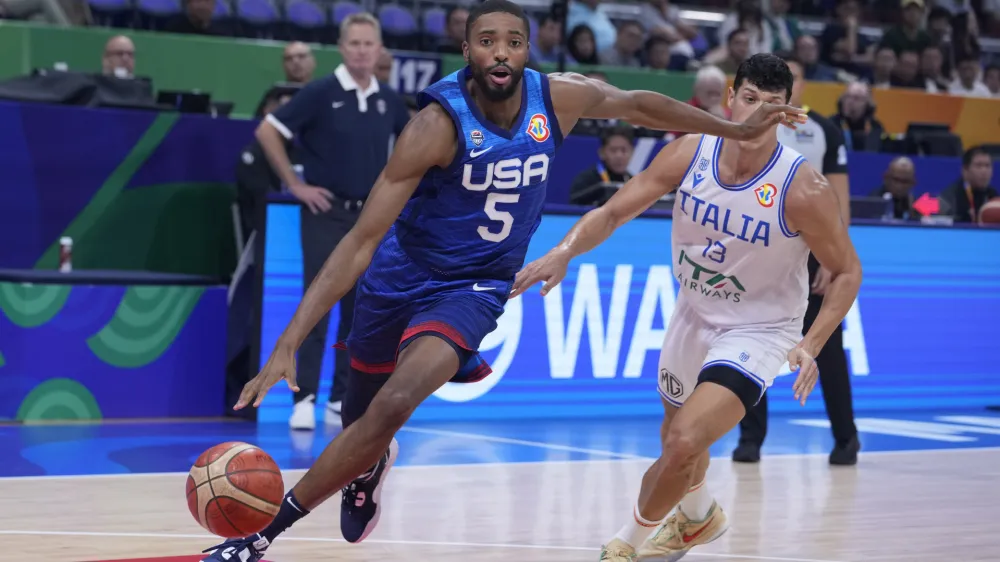 U.S. forward Mikal Bridges (5) drives past Italy forward Simone Fontecchio (13) during the Basketball World Cup quarterfinal game between Italy and U.S. at the Mall of Asia Arena in Manila, Philippines, Tuesday Sept. 5, 2023. (AP Photo/Michael Conroy)