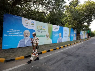 A security force personnel patrols past hoardings featuring India's Prime Minister Narendra Modi along an empty road ahead of the G20 Summit in New Delhi, India, September 8, 2023. REUTERS/Amit Dave