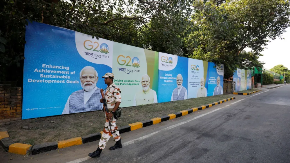 A security force personnel patrols past hoardings featuring India's Prime Minister Narendra Modi along an empty road ahead of the G20 Summit in New Delhi, India, September 8, 2023. REUTERS/Amit Dave