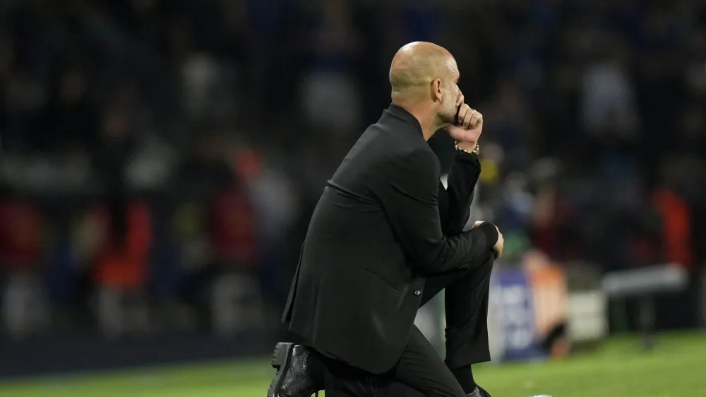 Manchester City's head coach Pep Guardiola kneels by the touchline during the Champions League final soccer match between Manchester City and Inter Milan at the Ataturk Olympic Stadium in Istanbul, Turkey, Saturday, June 10, 2023. (AP Photo/Francisco Seco)