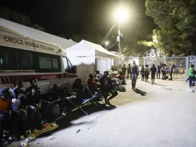 15 September 2023, Italy, Lampedusa: Migrants gather near an operational centre called "Hotspot" on the Italian island of Lampedusa. More than 8,000 boat migrants have landed on Lampedusa since the beginning of the week, leading to chaotic scenes in the Italian island's overcrowded reception centre. Photo: Cecilia Fabiano/LaPresse via ZUMA Press/dpa