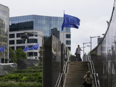 European Union flags flap in the wind as pedestrians walk by EU headquarters in Brussels, Wednesday, Sept. 20, 2023. The European Quarter is the headquarters of the main buildings of the European Union, inluding the European Parliament. (AP Photo/Virginia Mayo)