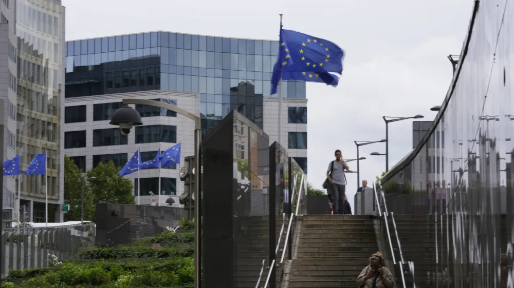 European Union flags flap in the wind as pedestrians walk by EU headquarters in Brussels, Wednesday, Sept. 20, 2023. The European Quarter is the headquarters of the main buildings of the European Union, inluding the European Parliament. (AP Photo/Virginia Mayo)