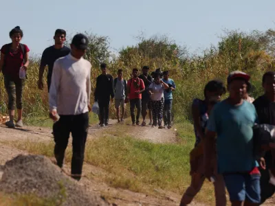 Migrants walk to turn themselves in to the U.S. Border Patrol after crossing the Rio Grande river and getting through the razor wire in Eagle Pass, Texas, U.S., September 28, 2023. REUTERS/Brian Snyder