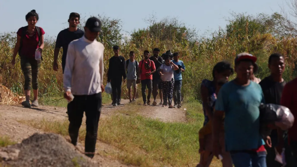 Migrants walk to turn themselves in to the U.S. Border Patrol after crossing the Rio Grande river and getting through the razor wire in Eagle Pass, Texas, U.S., September 28, 2023. REUTERS/Brian Snyder