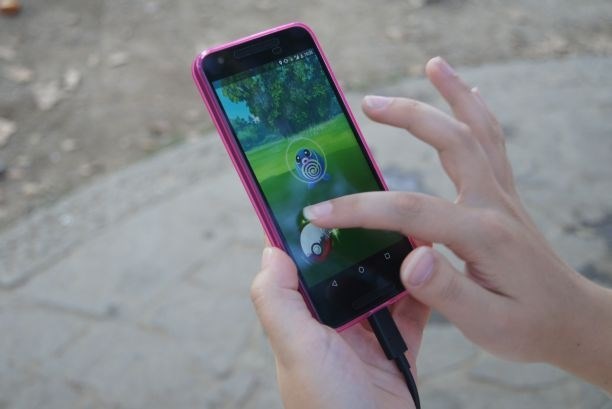 Igralci se med seboj prepoznajo po gibu prsta, s katerim med lovom zakrožijo po zaslonu. (Foto: Zala Štritof)
