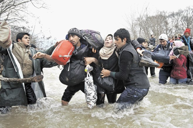 Begunci prečkajo reko, ko so marca skušali iz Grčije pribežati v Makedonijo.