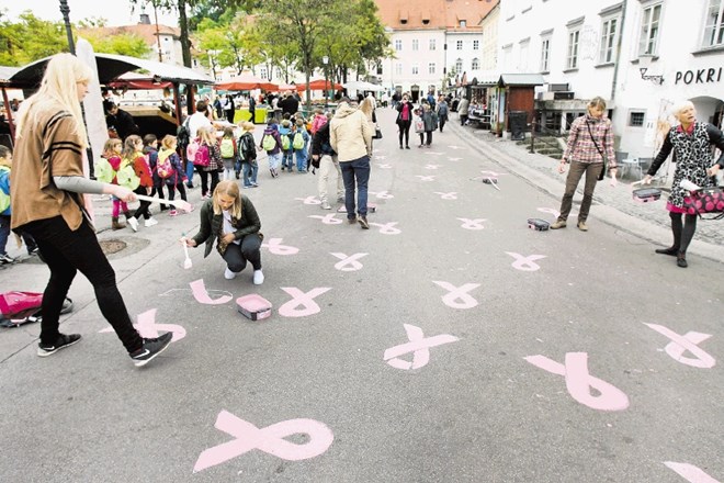 Ob vstopu v rožnati oktober so na ljubljanski tržnici in ob blagovnici Nama v središču Ljubljane narisali rožnate pentlje in...