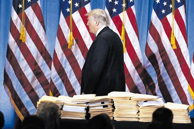 Donald Trump z goro  dokumentov, ki so jih njegovi sodelavci pripravili za novinarje na njegovi prvi tiskovni konferenci po...