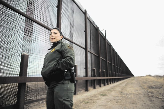 Agentka mejne patrulje stoji ob ograji pri El Pasu.