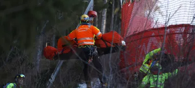 Medical staff are carrying France's Cyprien Sarrazin after crashing into protections net during an alpine ski, men's World Cup downhill training, in Bormio, Italy, Friday, Dec. 27, 2024. (AP Photo/Alessandro Trovati)