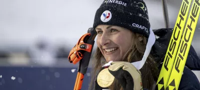 Justine Braisaz-Bouchet of France celebrates on podium winning the women's sprint race of the IBU Biathlon World Championships, Friday, Feb. 14, 2025, in Lenzerheide, Switzerland. (Gian Ehrenzeller/Keystone via AP)