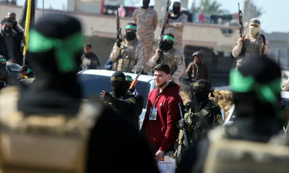 Russian-Israeli Sasha (Alexandre) Troufanov, a hostage held in Gaza since the deadly October 7, 2023 attack, is escorted by Palestinian Hamas militants and Islamic Jihad militants as part of a ceasefire and a hostages-prisoners swap deal between Hamas and Israel in Khan Younis, in the southern Gaza Strip, February 15, 2025. REUTERS/Hatem Khaled  REFILE - CORRECTING ID FROM "U.S.-ISRAELI SAGUI DEKEL-CHEN" TO "RUSSIAN-ISRAELI SASHA (ALEXANDRE) TROUFANOV".