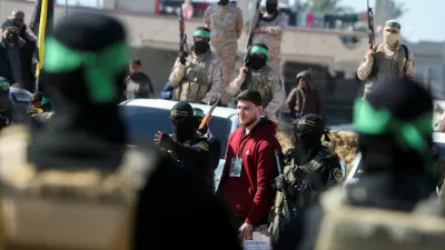 Russian-Israeli Sasha (Alexandre) Troufanov, a hostage held in Gaza since the deadly October 7, 2023 attack, is escorted by Palestinian Hamas militants and Islamic Jihad militants as part of a ceasefire and a hostages-prisoners swap deal between Hamas and Israel in Khan Younis, in the southern Gaza Strip, February 15, 2025. REUTERS/Hatem Khaled  REFILE - CORRECTING ID FROM "U.S.-ISRAELI SAGUI DEKEL-CHEN" TO "RUSSIAN-ISRAELI SASHA (ALEXANDRE) TROUFANOV".