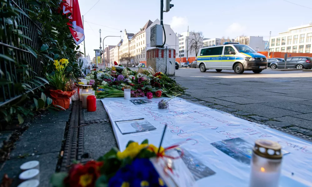 15 February 2025, Bavaria, Munich: A police emergency vehicle drives past flowers placed near the spot where a car drove into a group of demonstrators in Munich's city center last Thursday. The 24-year-old suspect in Thursday's vehicle attack in Munich confessed to intentionally crashing his car into a trade union rally, injuring at least 39 people, and investigators believe he acted out of an "Islamist motive," a senior Munich public prosecutor said on Friday. Photo: Pia Bayer/dpa