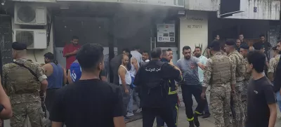 Lebanese soldiers and firefighters gather outside a mobile shop after what is believed to be the result of a walkie-talkie exploding inside it, in the southern port city of Sidon, Lebanon, Wednesday, Sept. 18, 2024. (AP Photo/Mohammed Zaatari)