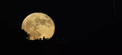 The moon rises in the sky over a freeway as drivers pass between Haifa and Tel Aviv, Israel, Wednesday, Sept. 18, 2024. (AP Photo/Ariel Schalit)