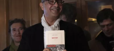 Algerian-French novelist Kamel Daoud holds his book Houris after being awarded with the Goncourt, France's most prestigious literary prize, Monday, Nov. 4, 2024 in Paris. (AP Photo/Aurelien Morissard)