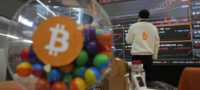 An employee watches an electronic signboard displaying the prices of Bitcoin and other cryptocurrencies at the lounge of Bithumb cryptocurrency exchange in Seoul, South Korea, Thursday, Nov. 21, 2024. (AP Photo/Ahn Young-joon)